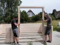 2 Männer bauen ein Gartenhaus auf